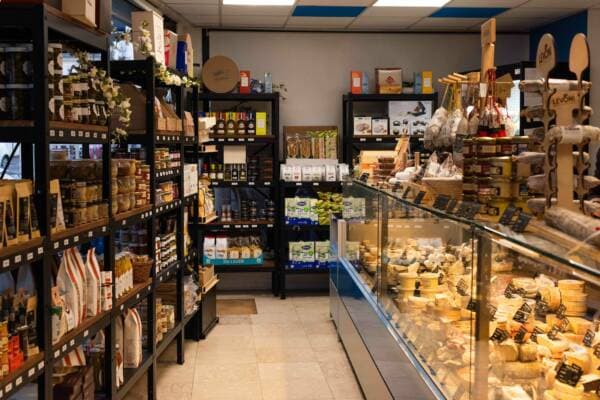 Les rayonnages d’épicerie fine et la vitrine à fromages de la boutique