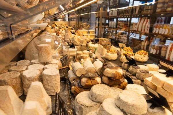 La vitrine à fromages vue de haut : crottins, cloche en verre et fromages aux fruits secs