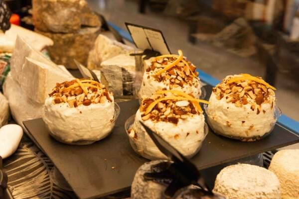 Trois fromages frais roulés dans des amandes effilées et des zestes d’orange, sur une ardoise