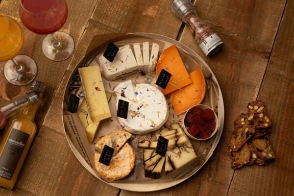 Plateau de fromages aux fleurs séchées et mimolette, servi avec des jus et des crackers