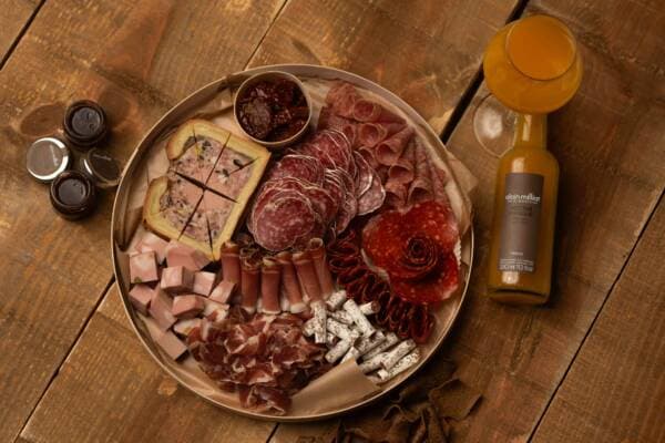 Plateau de charcuterie vu de dessus : pâté en croûte, rosette, jambon et rosace de chorizo